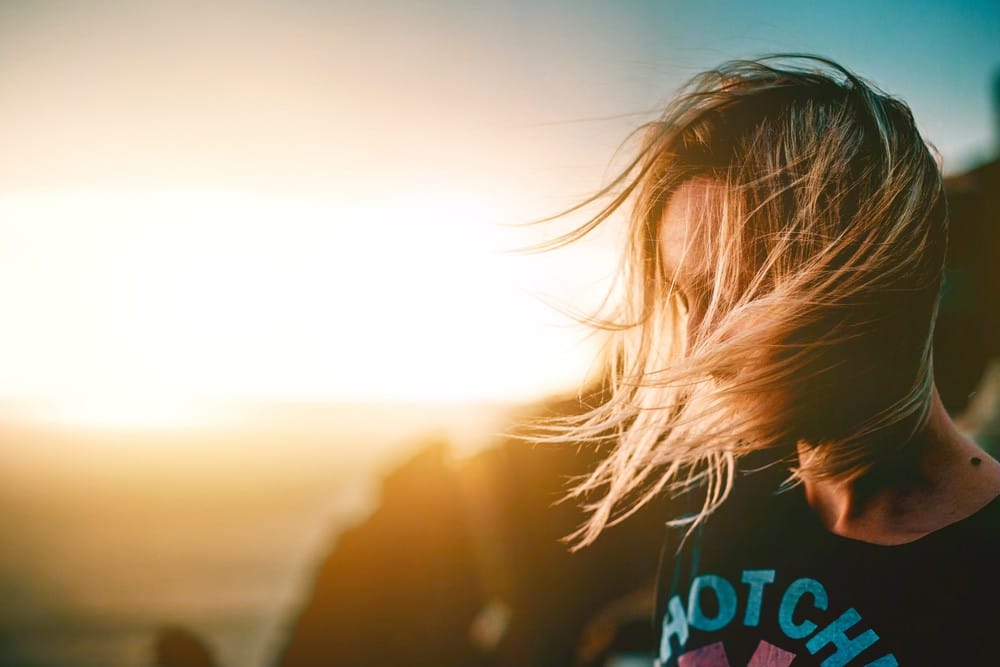 trámites chica rubia mirando al suelo y en una puesta de sol